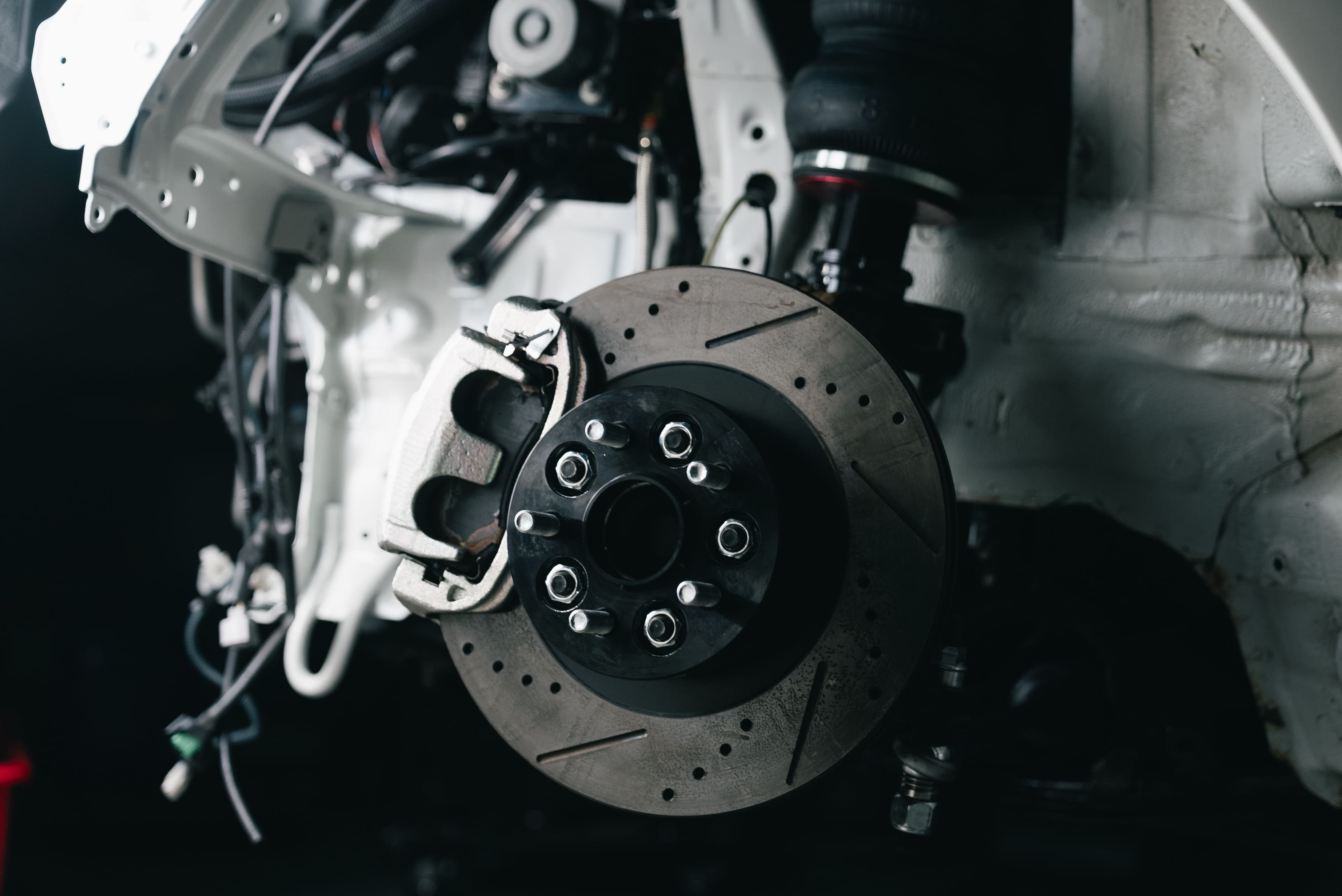 Mechanic inspecting vehicle brakes